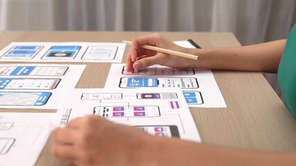 Panorama video of startup UX developer or company employee design user interface or UI prototype for mobile application or website software with software display on smartphone in office. Synergic