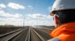 © MdNazim - Worker observing railway tracks hard hat orange jacket