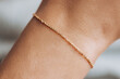 © Maria - Delicate gold bracelet gracing slender wrist, reflecting feminine elegance and refined personal style with minimalist jewelry accessory