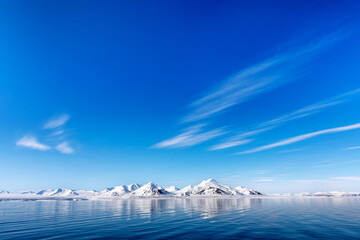 Wall Mural - the blue arctic ocean, pristine snow covered mountains and summer sky. svalbard, a norwegian archipe