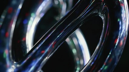 Abstract translucent glass tubes and reflections create futuristic and technology background with color lights and dark backdrop.