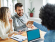 © Lumos sp - Portrait of a young couple shaking hands and closing a deal for aa new property purchase with real estate agent in her office