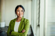 © BusinessClass by W61 - Confident businesswoman in green suit standing by office window