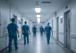 © GlambGarb - Blurred figures of medical professionals walking down a hospital corridor