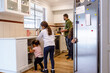© Austockphoto - Young daughter helping with household chores in the kitchen