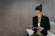 © Halfpoint - Portrait of young businesswoman working on tablet in office.