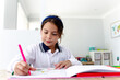 © Austockphoto - Young girl colouring a book on the table
