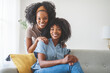 © Louis-Paul Photo - A affectionate mother and daughter sitting on sofa at home