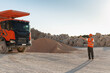 © Maria Vitkovska - Foreman coordinating operations in a quarry with a dumper truck and gravel pile
