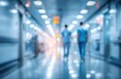 © tengah - Blurred image of two figures walking down a brightly lit, modern hallway with blue walls and tiled floor. Impressionistic, sterile atmosphere