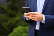 © New Africa - Businessman using smartphone outdoors, closeup. Space for text