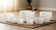 © Bindern - Collection of frosted crystal singing bowls and a mallet arranged on a natural fiber rug, creating a serene and meditative atmosphere