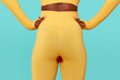 © French Anderson Ltd/Stocksy - Woman in yellow workout clothes with period leak against blue
