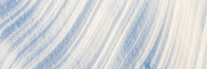 Wall Mural - Beautiful winter background with snowy ground. Natural snow texture. Wind sculpted patterns on snow surface. Wide panoramic texture for background and design.