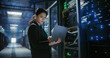 © Aleksei Gorodenkov/Stocksy - SYS Admin uses laptop in data center.