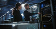 © Aleksei Gorodenkov/Stocksy - Two server specialists talk and work in data center.