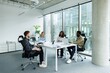 © Oleksii Syrotkin/Stocksy - Group of smiling multiethnic architects looking at red hair colleague