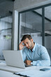 © Stock 4 You - Confused young businessman looking disappointed at laptop pc computer screen having stress. European business man holding hand near temples, feeling stressed and tired sitting in office. Vertical