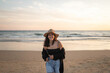 © Lupe Rodriguez/Stocksy - Teenage girl portrait on beach at sunset wearing hat