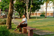 © Watcharawit Phudork/Stocksy - Young Southeast Asian woman relaxing in a park at sunset