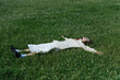 © Darina Belonogova/Stocksy - Woman in White Outfit Lying in Green Meadow