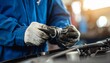 © photostockatinat - Mechanic's hands are carefully fixing the car engine. The mechanic is wearing protective gloves and the car is in the garage. This scene suggests reliability, precision.
