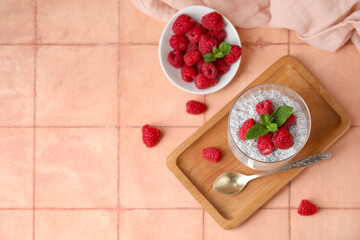 Wall Mural - Glass of tasty chia seed pudding with fresh raspberries and mint on beige tile background