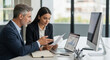 © l1gend - Team of diverse partners mature man and young woman discussing financial document using computer sitting at table in office. Two colleagues of professional business people working together on project