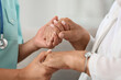 © Pixel-Shot - Female caregiver with senior woman holding hands at home, closeup