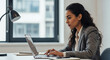 © l1gend - Young professional it specialist latin hispanic business lady working on laptop pc sitting at desk in modern office space. 30s middle eastern indian woman using computer technology app for work online