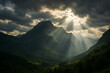 © dhiyaulhaq - A breathtaking view of a majestic mountain landscape, with dramatic lighting and sunlight filtering through the clouds, casting rays over the valley below.