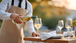 © MACKY - waiter pouring white wine into a wine glass at a restaurant, dining experience