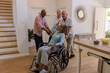 © wavebreak3 - Senior friends laughing and enjoying time together at home with wheelchair
