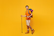 © ViDi Studio - Full body young traveler man carrying backpack with stuff mat trekking poles isolated on plain yellow background. Tourist lead active lifestyle walk on spare time Hiking trek rest travel trip concept