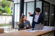 © Wasana - Business people discussing work in office meeting using laptop and documents
