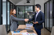 © Wasana - Businesspeople shaking hands over a table after closing a business deal