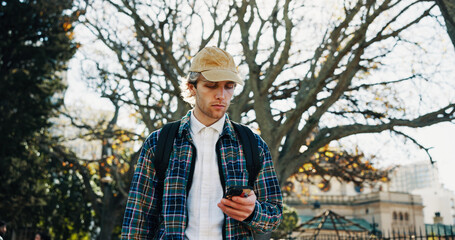 University, outdoor and man with smartphone, student and social media with communication. Campus, college and person with cellphone, internet or email with test results, network or message to contact