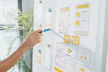 a young designer is working on a ux ui project, analyzing mobile app wireframes and choosing color p