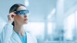© Дмитрий Баронин - Female scientist wearing smart glasses in a modern laboratory, examining data on a digital interface, showcasing innovation and technology in research and development