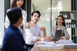 © Wasan - Group businesspeople happy while collaborating on a new project in an office. Businessman leading a discussion during a meeting with colleagues. Businesswoman interacting with a colleague.
