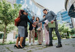 © qunica.com - A team of diverse colleagues engaging in a collaborative activity outdoors near office buildings, showcasing teamwork, positivity, and a professional environment.
