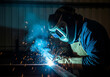 © Alze31 - Welder working on metal in workshop with sparks flying and protective gear on, showcasing industrial craftsmanship and safety measures.