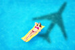 © New Africa - Young woman on inflatable mattress in swimming pool, above view. Flying airplane casting shadow on water