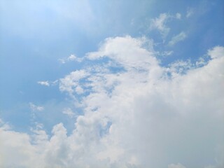 Wall Mural - Beautiful clear blue sky with soft cloud formations in summer. Soft white clouds float in the clear blue sky. Peaceful and beautiful natural sky background for design or nature concepts.