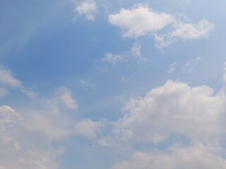 Wall Mural - Beautiful clear blue sky with soft cloud formations in summer. Soft white clouds float in the clear blue sky. Peaceful and beautiful natural sky background for design or nature concepts.