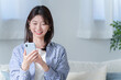 © polkadot - スマホを使う笑顔の若い女性