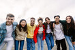 © Xavier Lorenzo - Young group of teenage friends smiling at camera hugging each other outdoors. Unity, friendship lifestyle and youth community concept