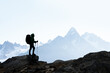 © Ivan Kmit - Adventurers silhouette against misty high-altitude snowy peaks. Wilderness and travel inspiration. Backpacker in mountains