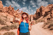 © EdNurg - Happy female tourist taking selfie with smartphone while visiting Charyn Canyon in Kazakhstan