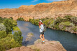 © EdNurg - Tourist with a backpack admiring the breathtaking views of the Charyn river and canyon in Kazakhstan, embracing the spirit of adventure